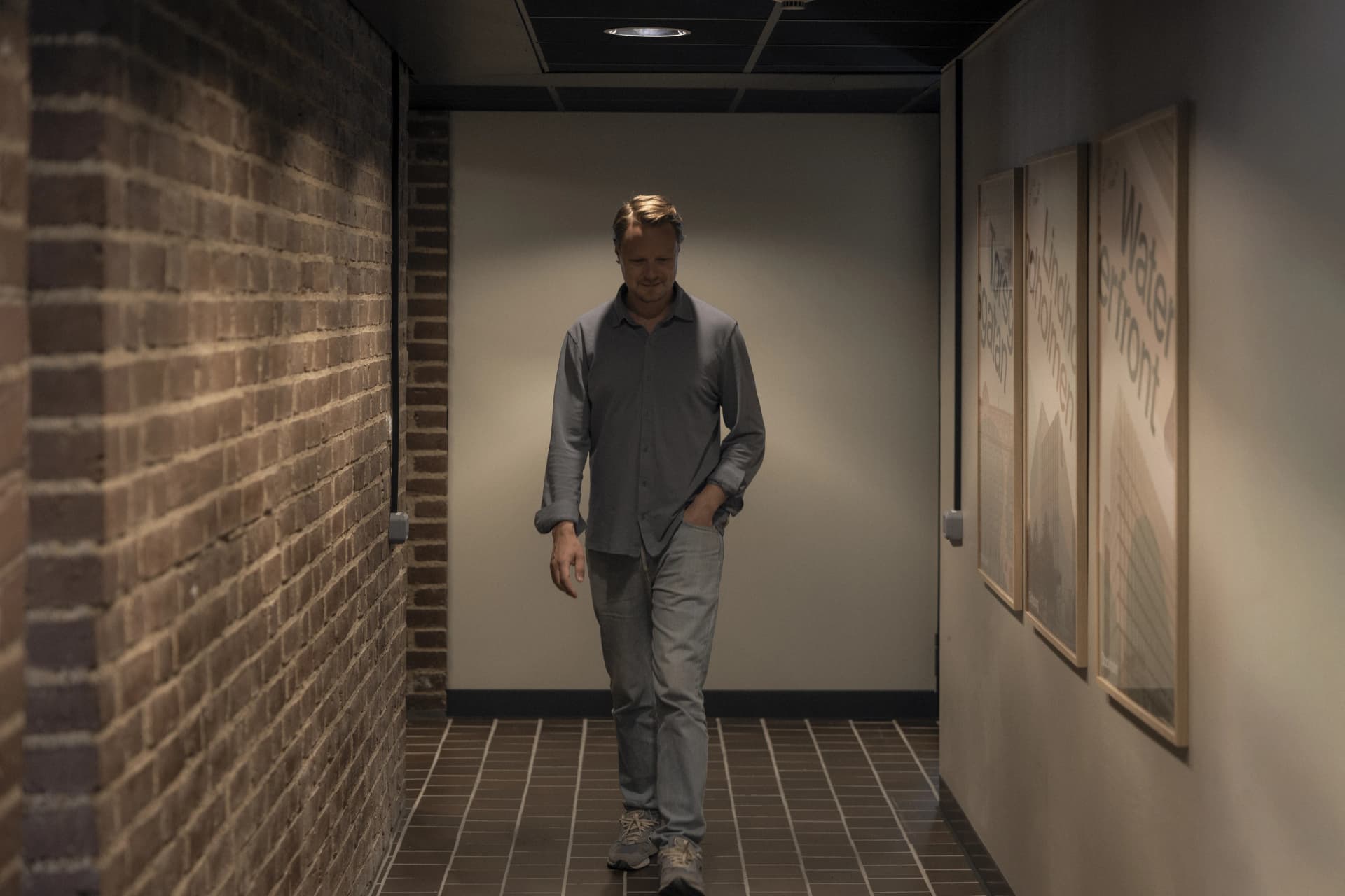 Person walking through a dimly lit corridor.