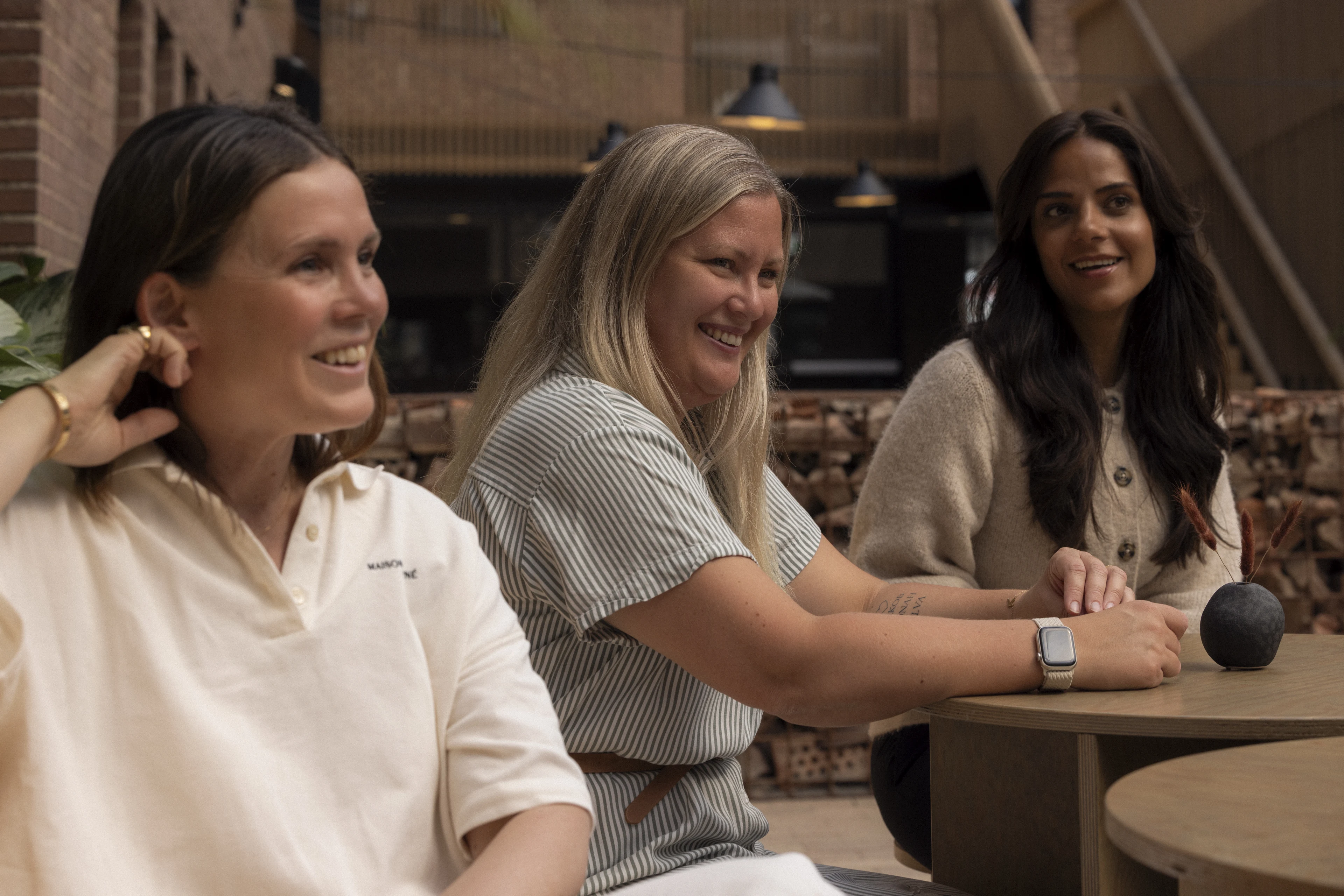 Colleagues talking and smiling at a table.