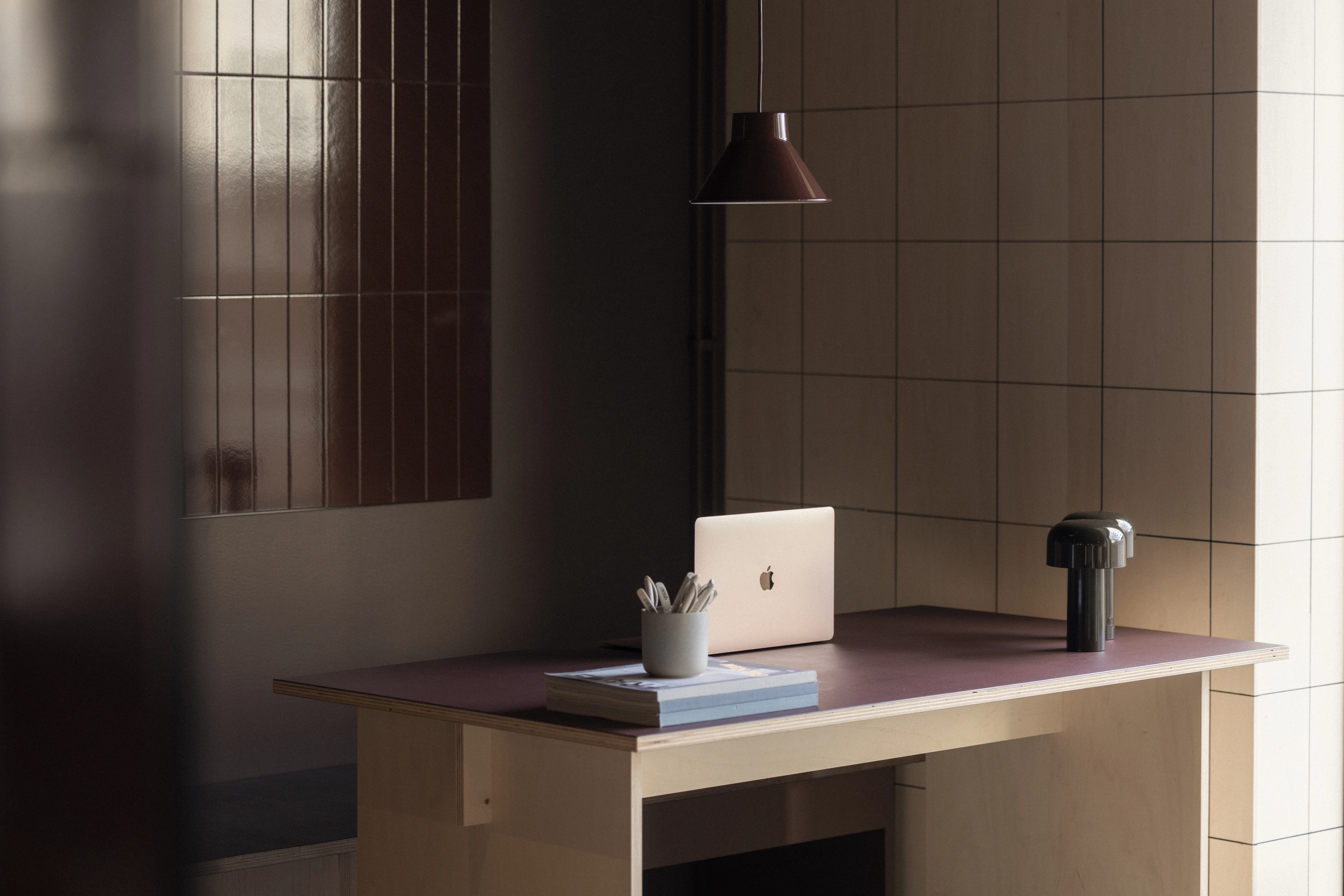 Aufgeräumter Arbeitsplatz mit Bildschirm und Lampe.