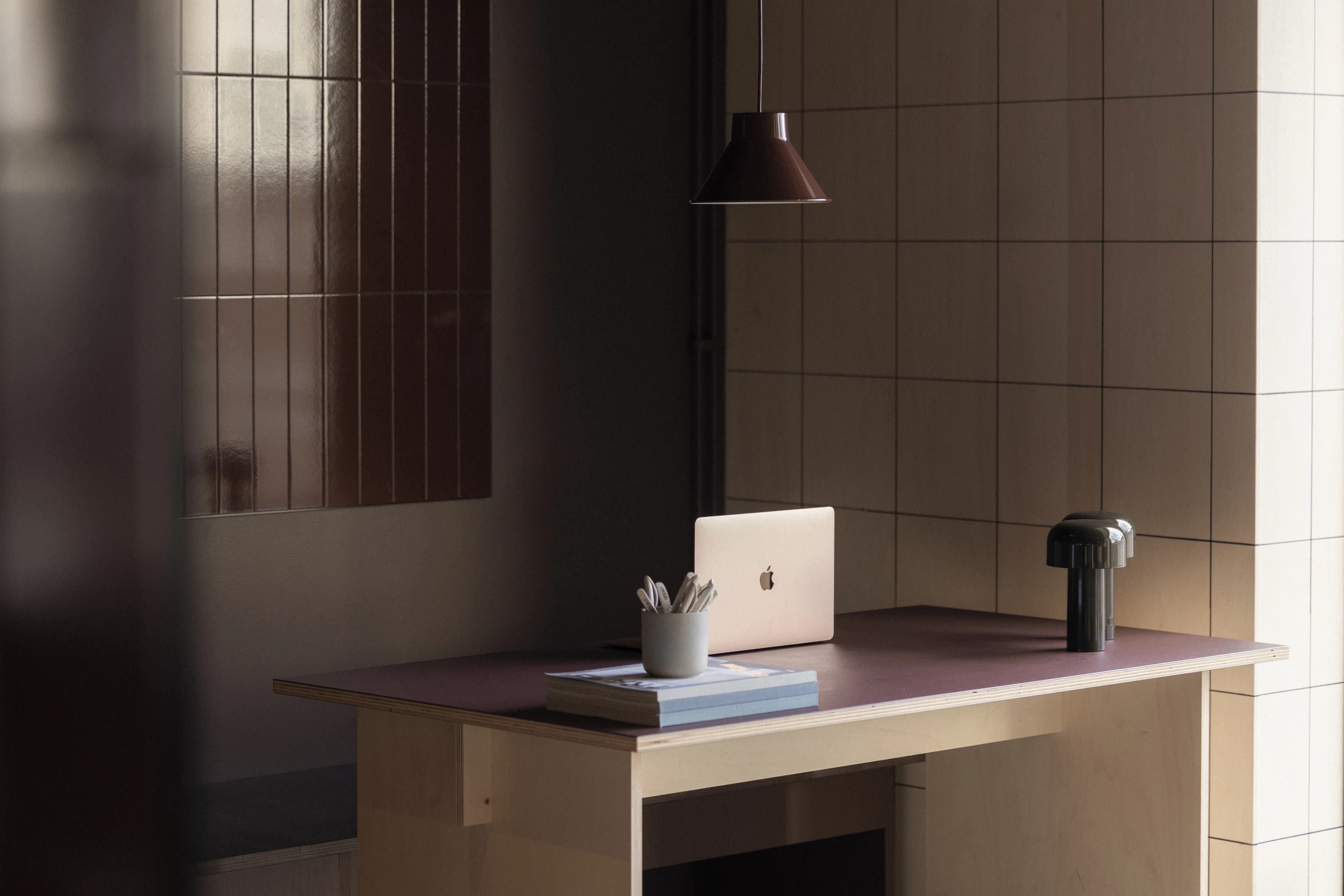 Aufgeräumter Arbeitsplatz mit Bildschirm und Lampe.