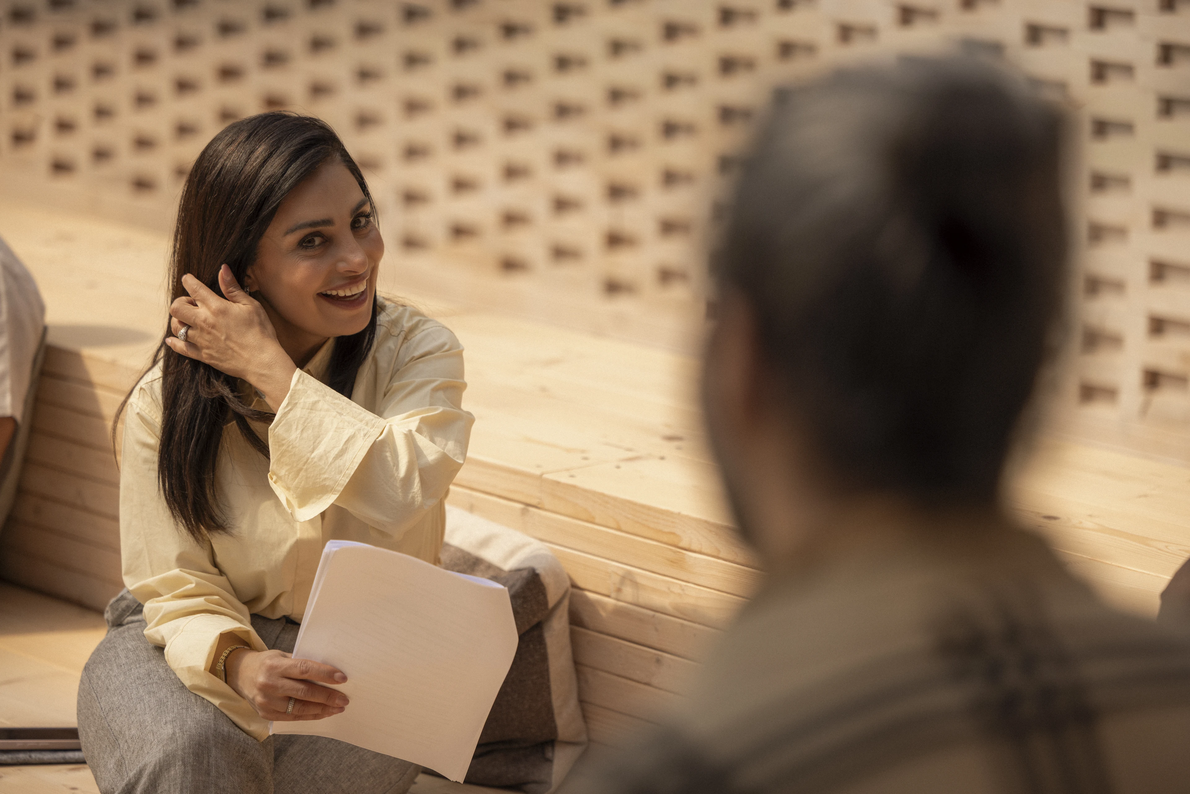 Woman talking, holding documents.